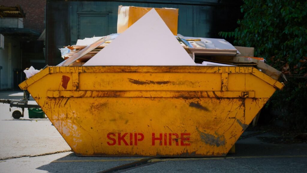 A yellow overload skip hire container, used for waste disposal