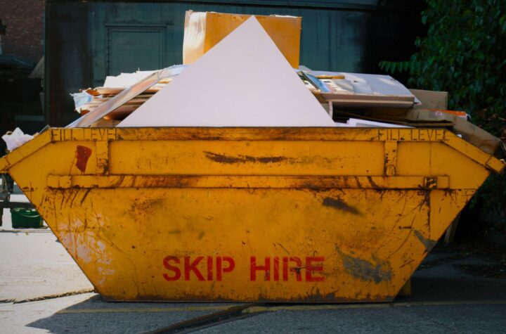 A yellow overload skip hire container, used for waste disposal