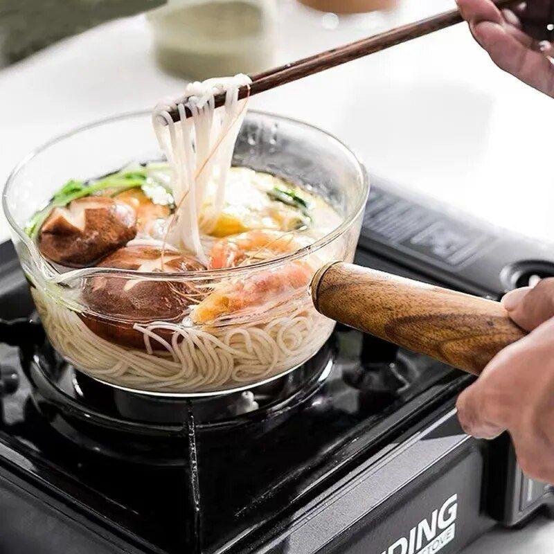 glass cooking pot with a wooden handle